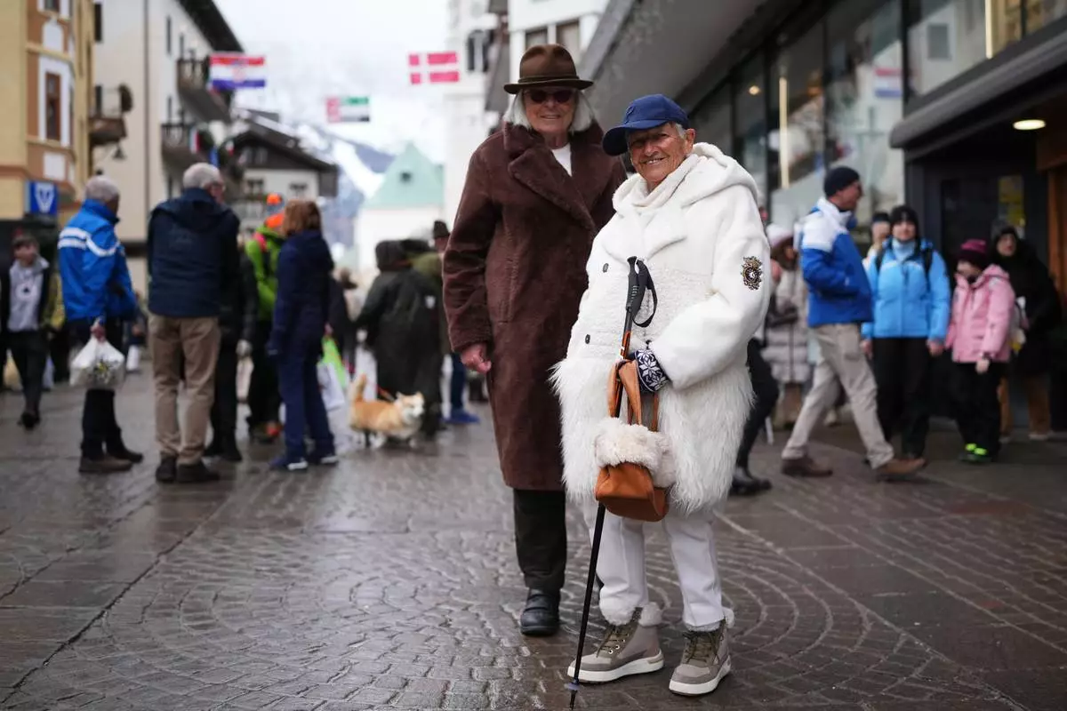 Marina Bozzoli, 82, and Orietta Guarini, 83, pose for a photo in Cortina d'Ampezzo, Italy, Saturday, Feb. 14, 2026. (AP Photo/Alessandra Tarantino)