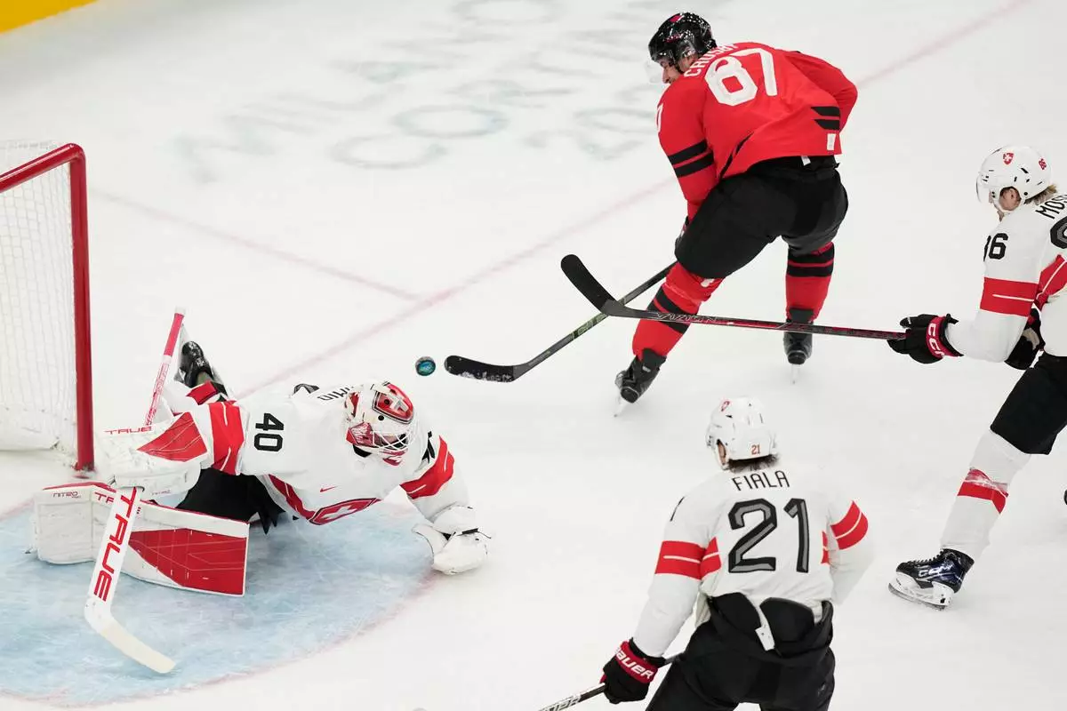 Canada's Sidney Crosby, right, fails to score past Switzerland's goalkeeper Akira Schmid during a preliminary round match of men's ice hockey between Canada and Switzerland at the 2026 Winter Olympics, in Milan, Italy, Friday, Feb. 13, 2026. (AP Photo/Hassan Ammar)