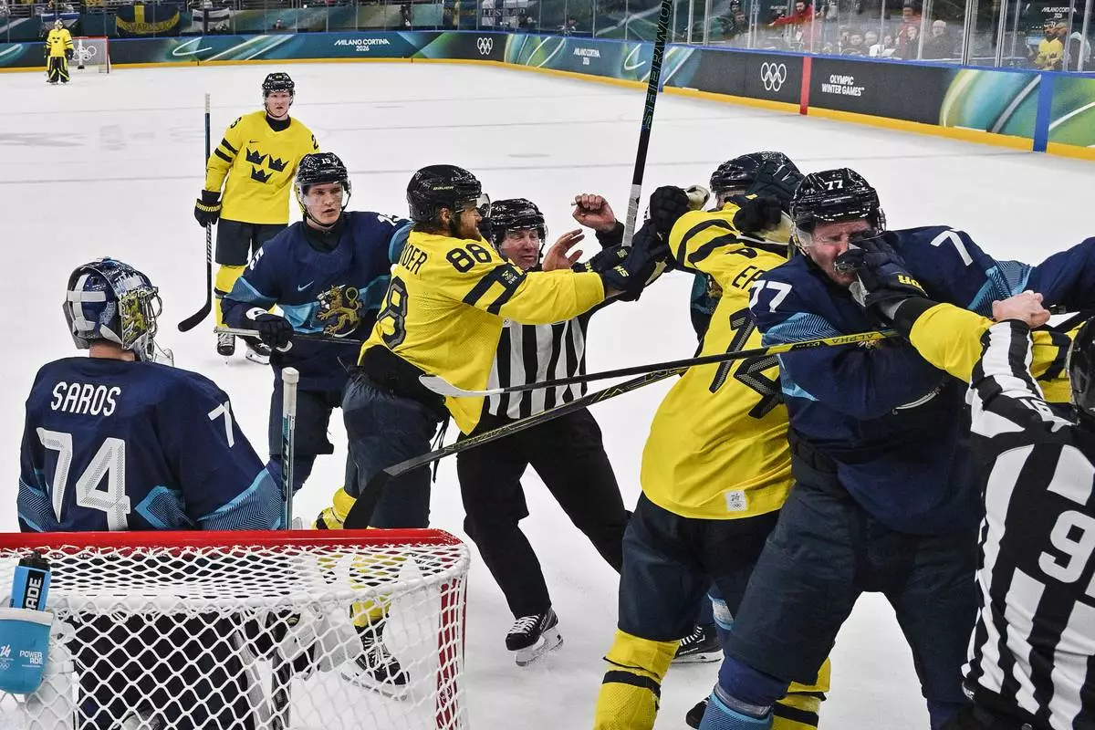 Sweden and Finland players fight, during a preliminary round match of men's ice hockey between Finland and Sweden at the 2026 Winter Olympics, in Milan, Italy, Friday, Feb. 13, 2026. (Alexander Nemenov/Pool Photo via AP)