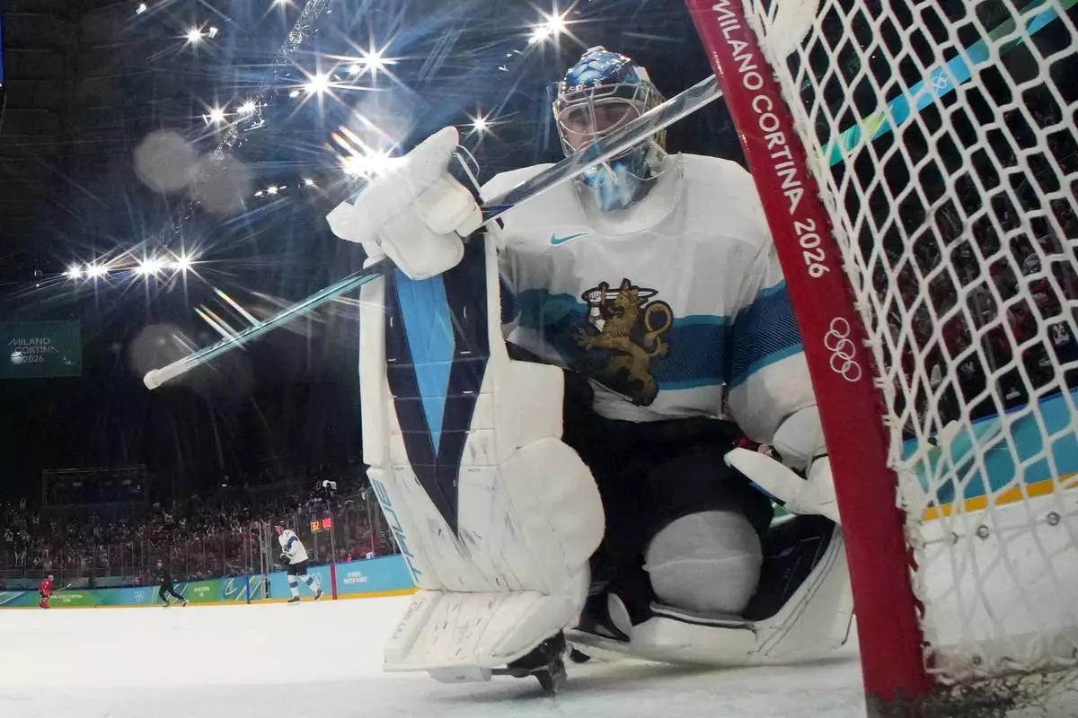 Finland's Juuse Saros reacts after Canada's Nathan MacKinnon, not seen, scored his side's third goal during a men's ice hockey semifinal game between Canada and Finland at the 2026 Winter Olympics, in Milan, Italy, Friday, Feb. 20, 2026. (Mike Segar/Pool Photo via AP)