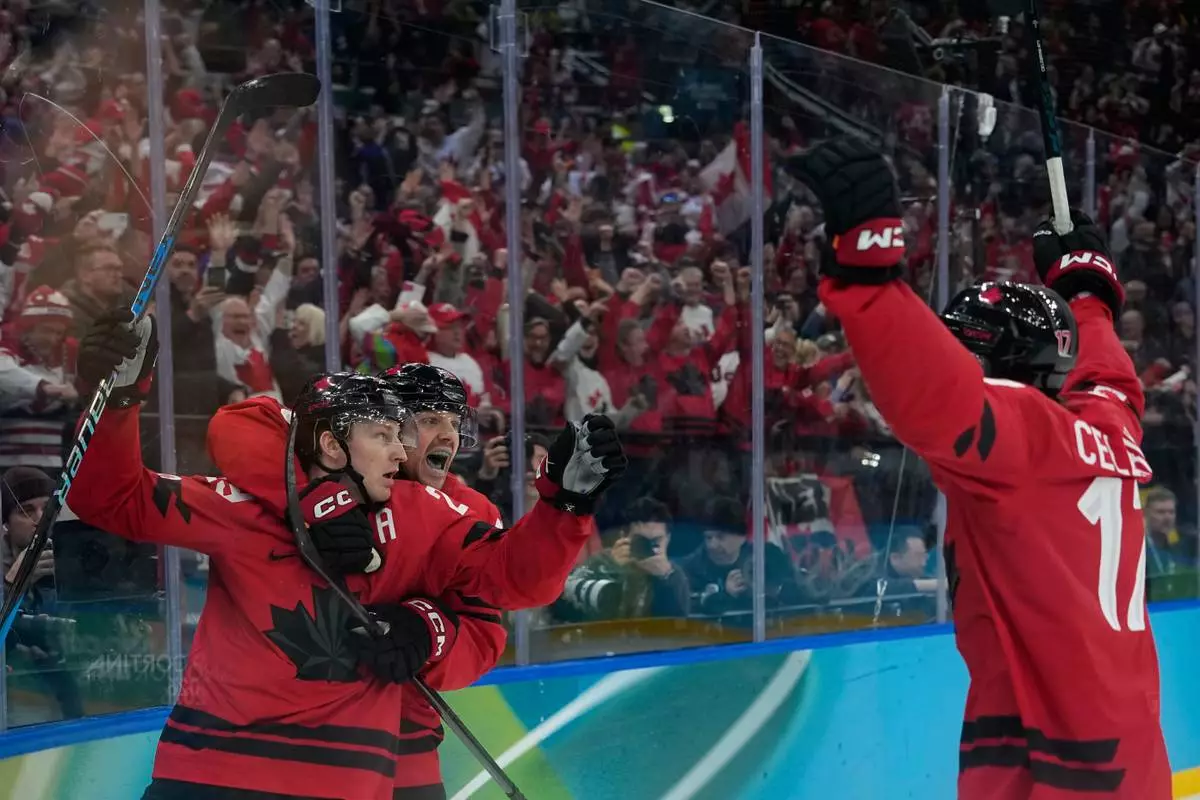 Canada's Nathan MacKinnon (29) celebrates with teammates after scoring his side's third goal during a men's ice hockey semifinal game between Canada and Finland at the 2026 Winter Olympics, in Milan, Italy, Friday, Feb. 20, 2026. (AP Photo/Petr David Josek)