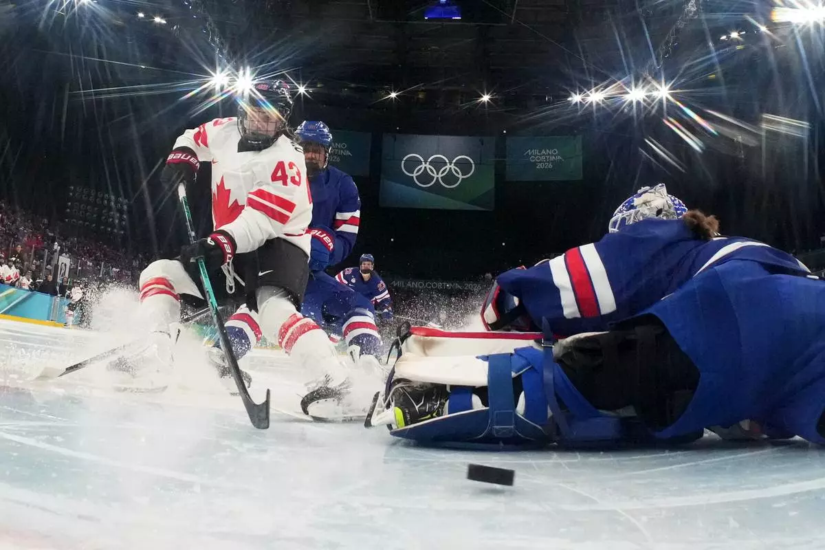 Canada's Kristin O'Neill (43) scores her side's opening goal during a women's ice hockey gold medal game between the United States and Canada at the 2026 Winter Olympics, in Milan, Italy, Thursday, Feb. 19, 2026. (David W Cerny/Pool Photo via AP)