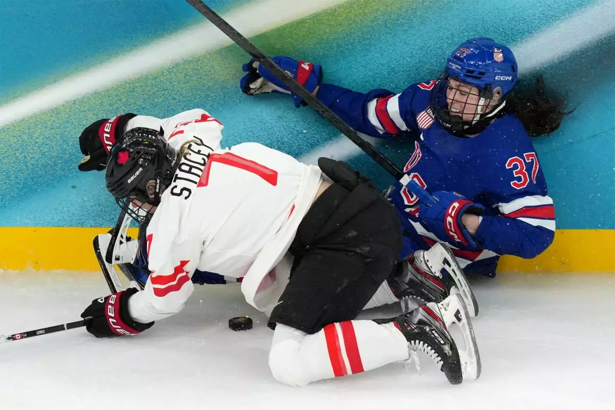 Canada's Laura Stacey (7) and United States' Abbey Murphy (37) battle for the puck during the second period of the women's ice hockey gold medal game at the 2026 Winter Olympics, in Milan, Italy, Thursday, Feb. 19, 2026. (AP Photo/Carolyn Kaster)