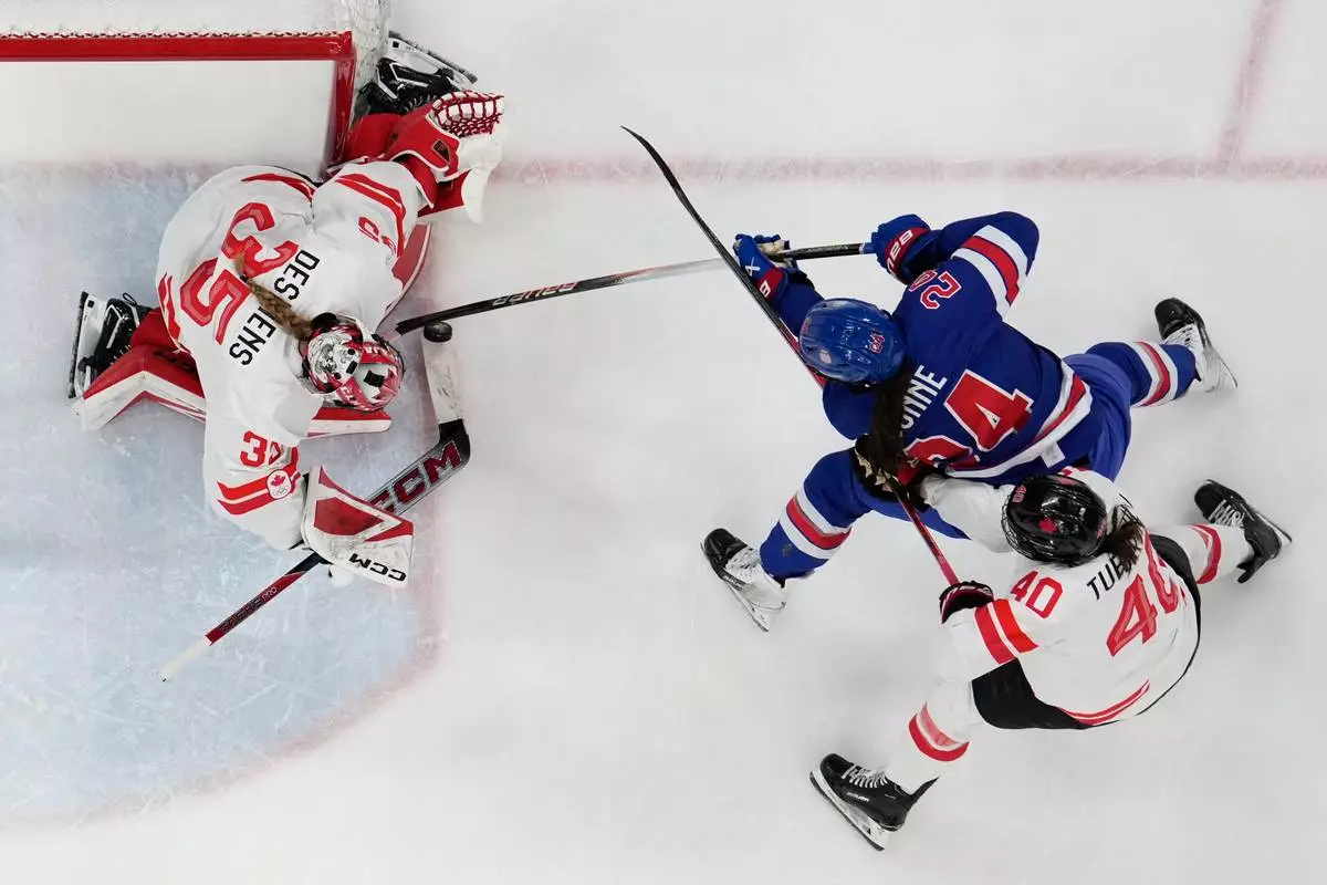 United States' Joy Dunne (24) challenges with Canada's Blayre Turnbull (40) during a women's ice hockey gold medal game between the United States and Canada at the 2026 Winter Olympics, in Milan, Italy, Thursday, Feb. 19, 2026. (AP Photo/Petr David Josek)