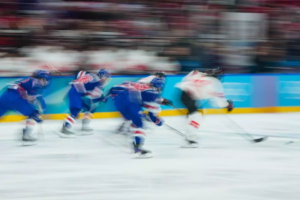 Players follow the puck during a women's ice hockey gold medal game between the United States and Canada at the 2026 Winter Olympics, in Milan, Italy, Thursday, Feb. 19, 2026. (AP Photo/Petr David Josek)