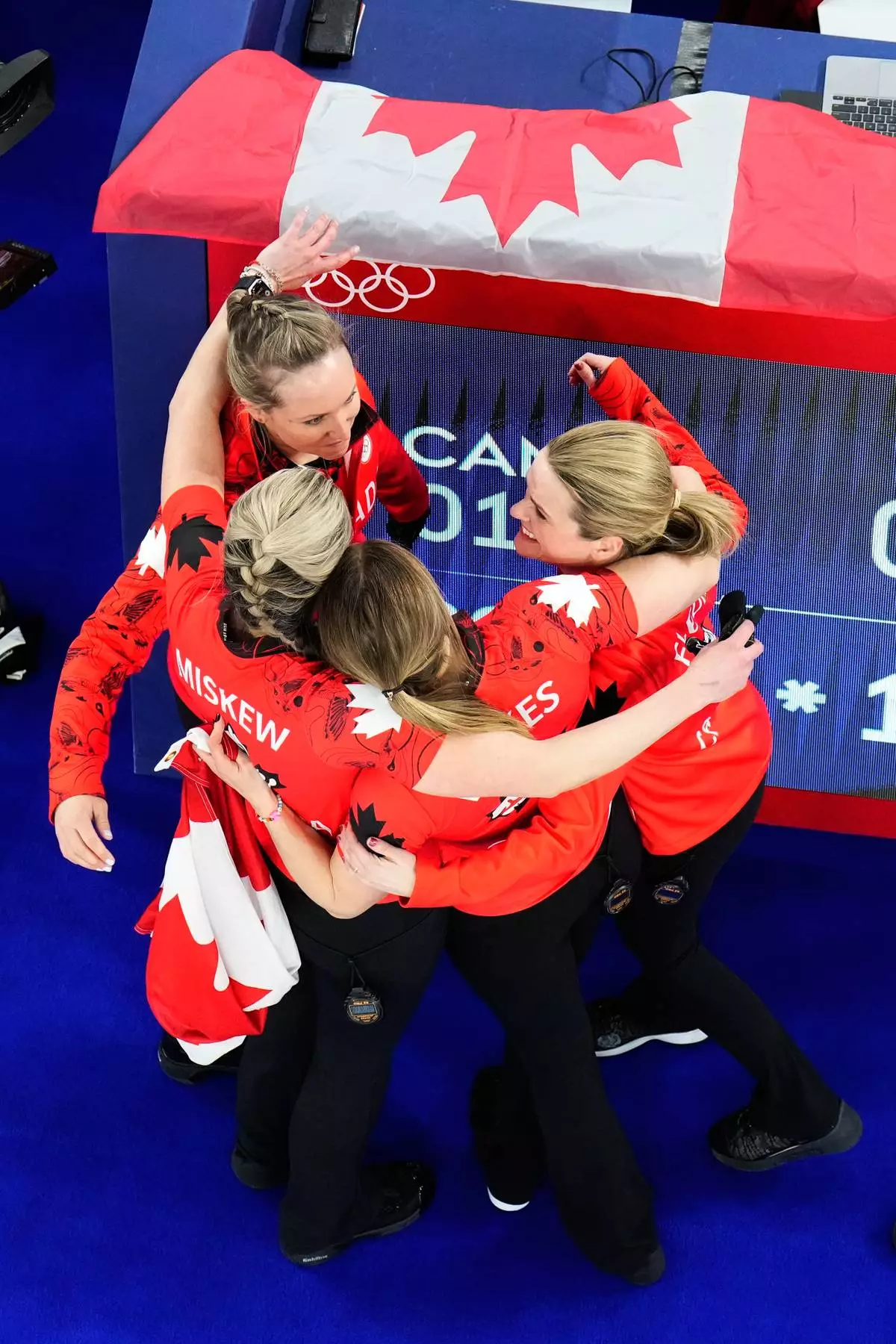 Canada's Rachel Homan, Tracy Fleury, Emma Miskew, and Sarah Wilkes celebrate after winning the women's curling bronze medal match against the United States at the 2026 Winter Olympics, in Cortina d'Ampezzo, Italy, Saturday, Feb. 21, 2026. (AP Photo/David J. Phillip)