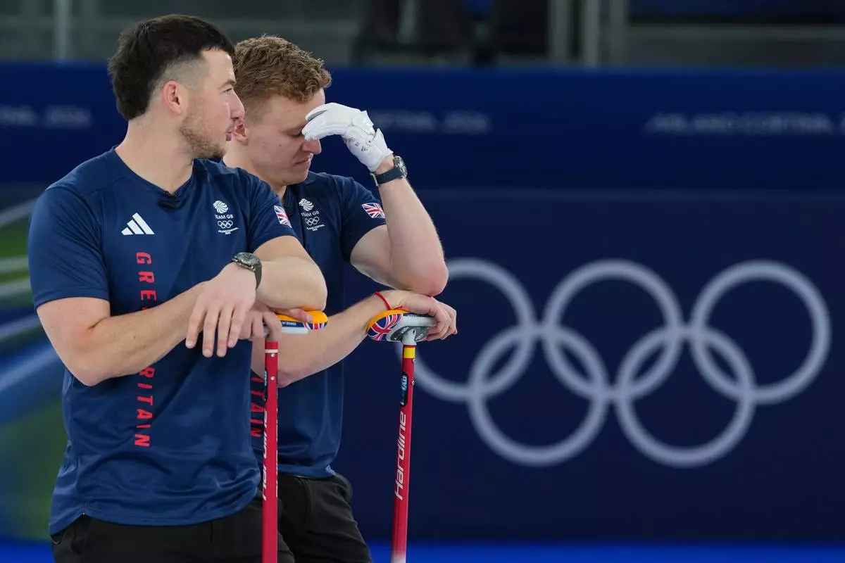 Britain's Bobby Lammie and Hammy McMillan, left, during a men's curling gold medal match between Britain and Canada, at the 2026 Winter Olympics, in Cortina d'Ampezzo, Italy, Saturday, Feb. 21, 2026. (AP Photo/Misper Apawu)