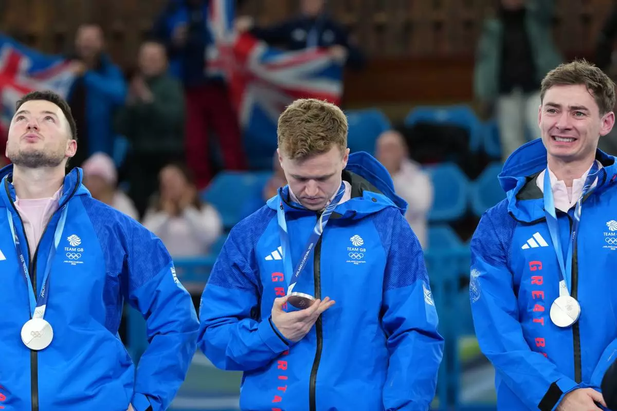 From left, Britain's Hammy McMillan, Bobby Lammie and Grant Hardie pose with the silver medals of the men's curling, at the 2026 Winter Olympics, in Cortina d'Ampezzo, Italy, Saturday, Feb. 21, 2026. (AP Photo/Misper Apawu)