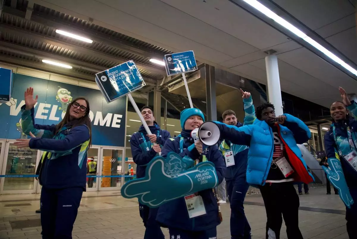 2026 Winter Olympics volunteers gesture at the venue that hosts the women’s ice hockey, in Milan, Italy, Monday, Feb. 9, 2026. (AP Photo/Vasilisa Stepanenko)
