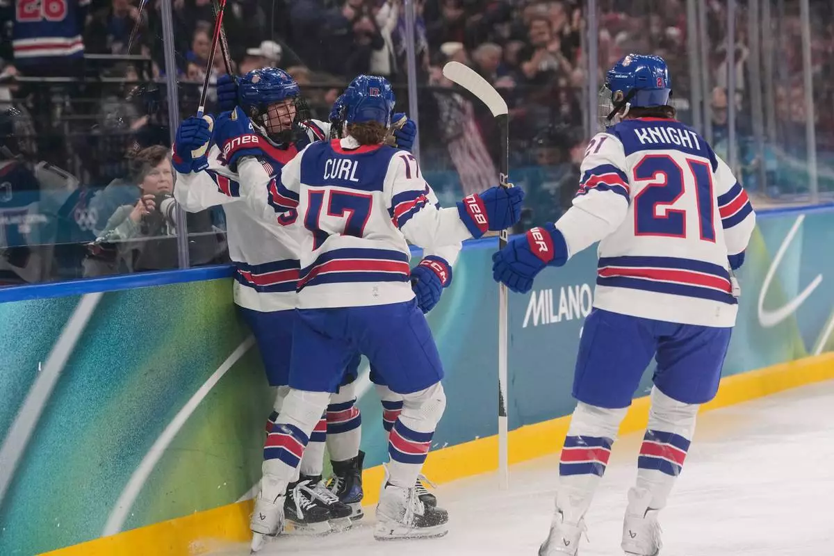 United States' Caroline Harvey celebrates with teammates after scoring her side's first goal during a preliminary round match of women's ice hockey between USA and Canada at the 2026 Winter Olympics, in Milan, Italy, Tuesday, Feb. 10, 2026. (AP Photo/Petr David Josek)