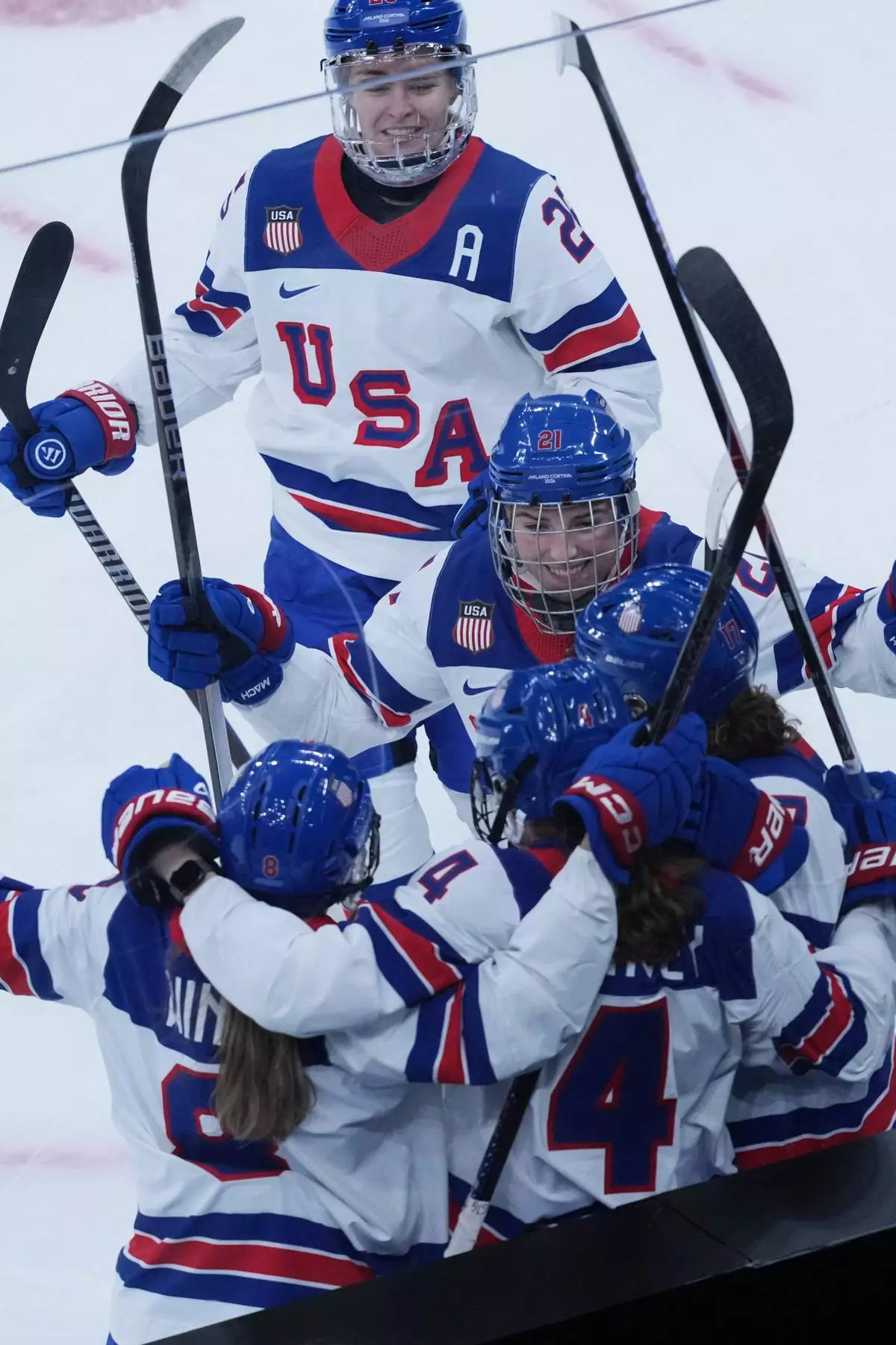 United States' Caroline Harvey celebrates with teammates after scoring her side's first goal during a preliminary round match of women's ice hockey between USA and Canada at the 2026 Winter Olympics, in Milan, Italy, Tuesday, Feb. 10, 2026. (AP Photo/Antonio Calanni)