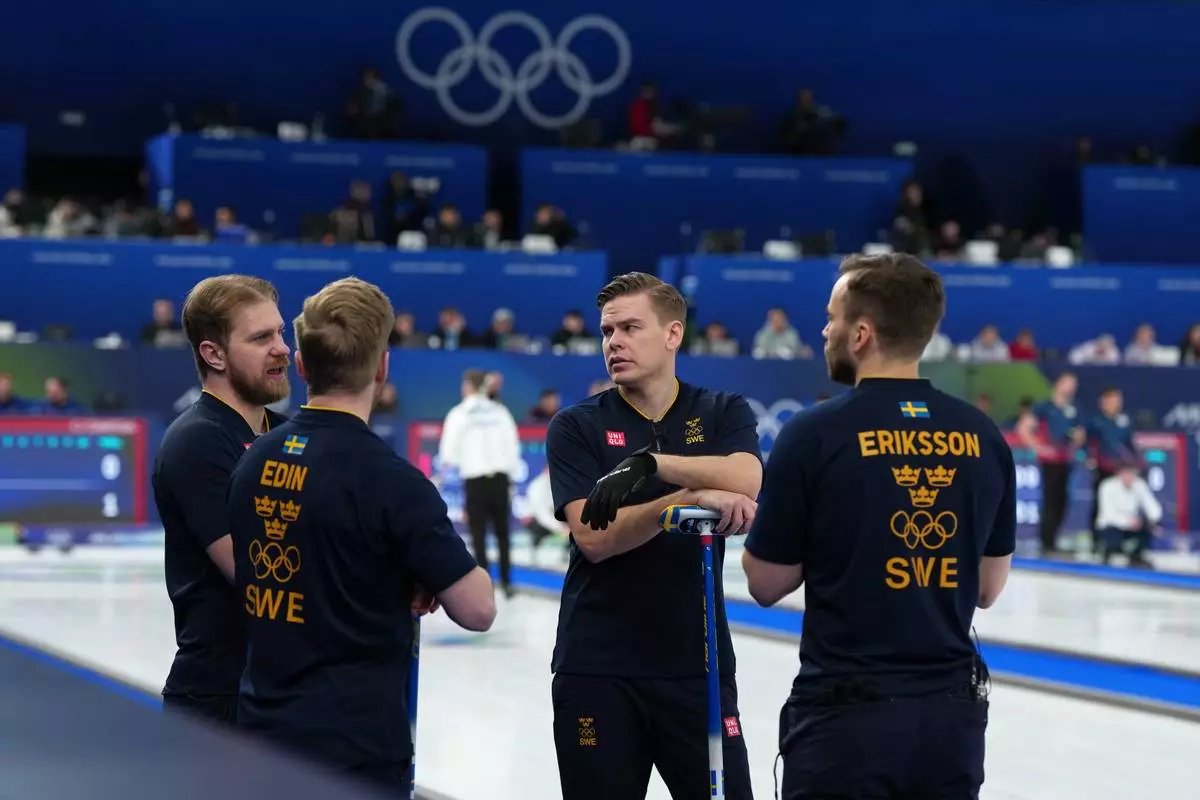 Sweden's Oskar Eriksson, right, Christoffer Sundgren, second right, Rasmus Wranaa, left, and Niklas Edin, second left, in action during the men's curling round robin session against Italy, at the 2026 Winter Olympics, in Cortina d'Ampezzo, Italy, Wednesday, Feb. 11, 2026. (AP Photo/Misper Apawu)