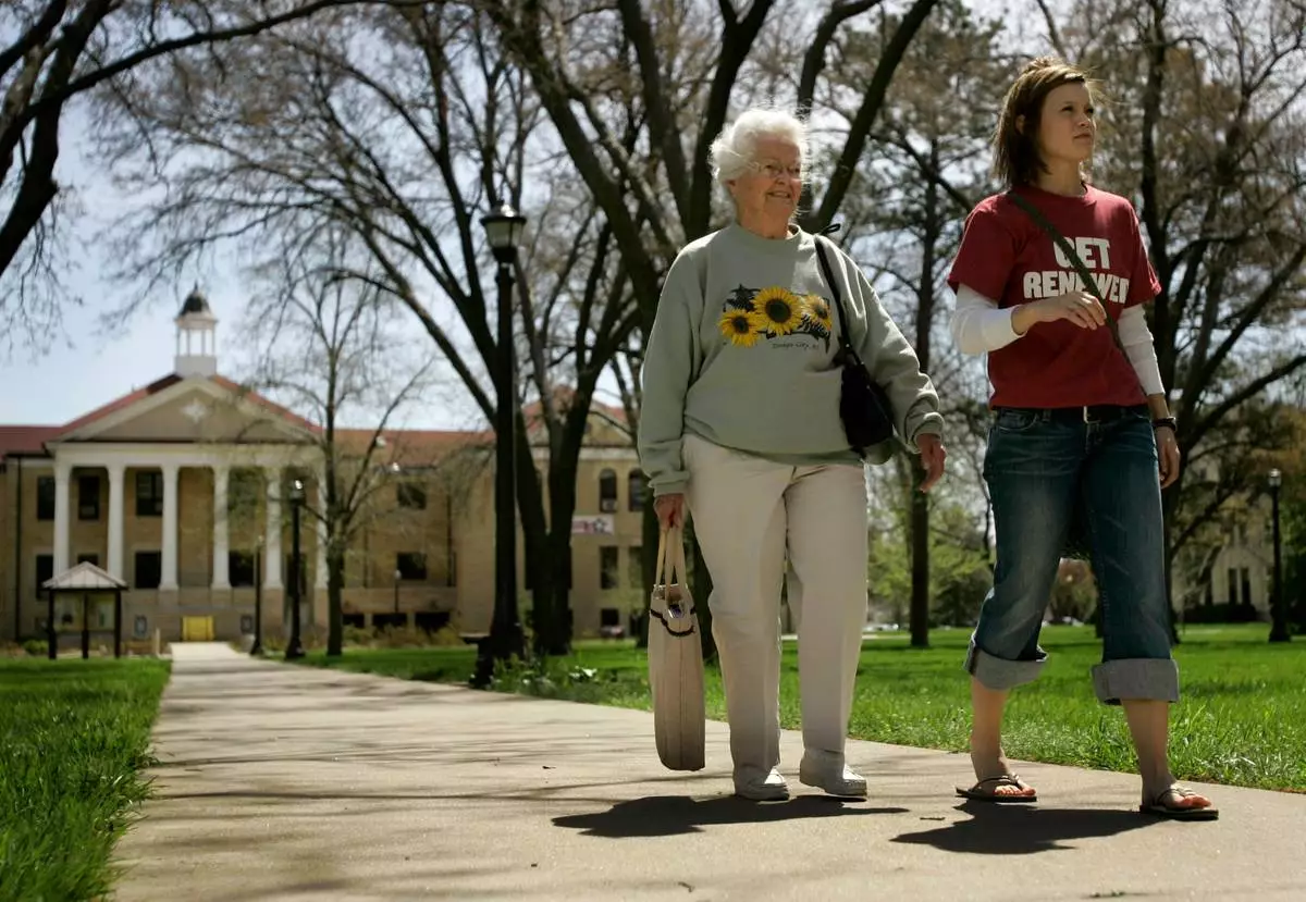 FILE - Nola Ochs and her granddaughter, Alexandra Ochs, right, walk across the Fort Hays State University campus between classes Monday, April 23, 2007 in Hays, Kan. (AP Photo/Charlie Riedel, File)