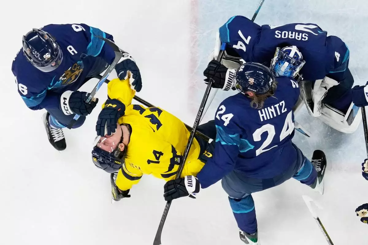 Finland's Roope Hintz, right, challenges Sweden's Joel Eriksson Ek during a preliminary round match of men's ice hockey between Finland and Sweden at the 2026 Winter Olympics, in Milan, Italy, Friday, Feb. 13, 2026. (AP Photo/Petr David Josek)