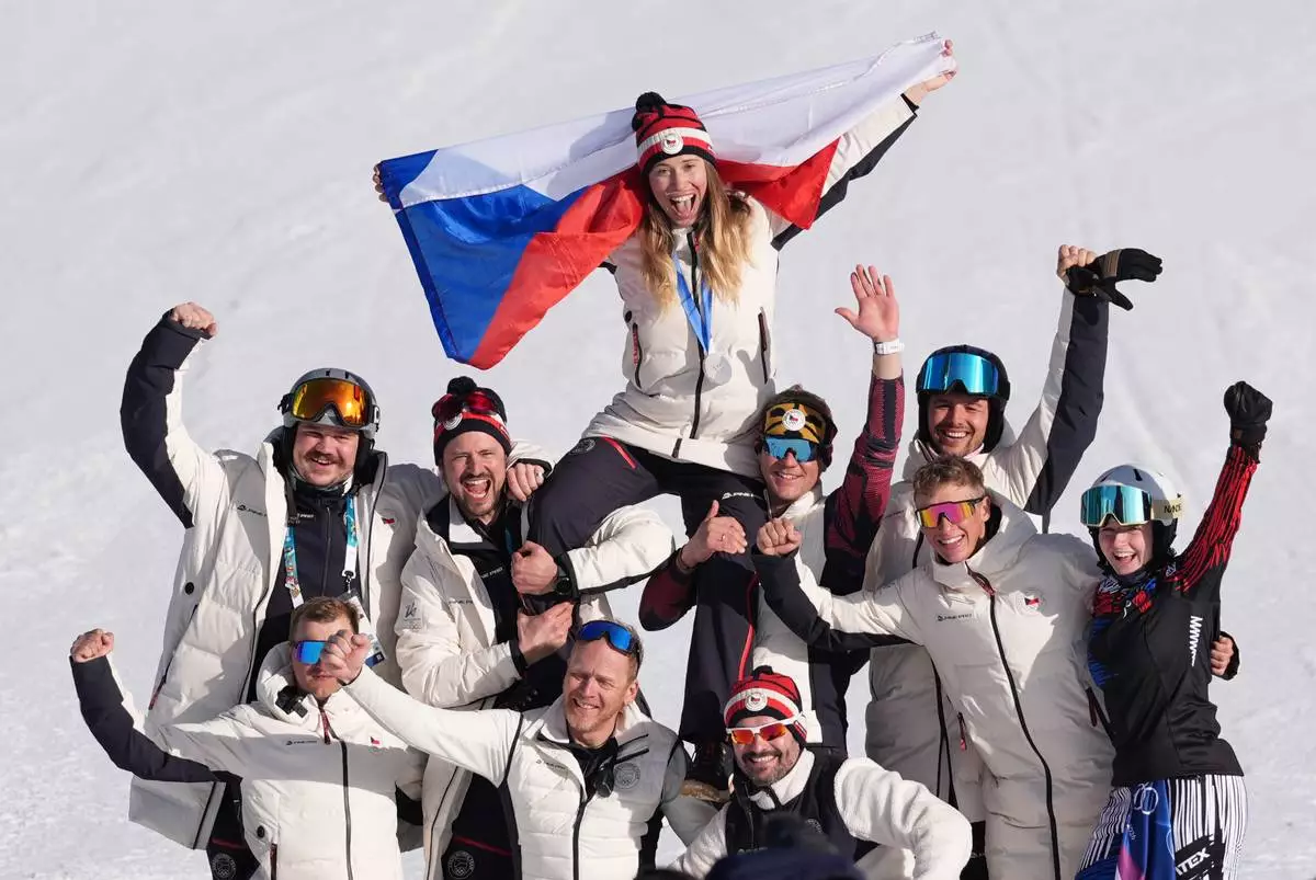 Silver medalist Czechia's Eva Adamczykova celebrates with team members after the women's snowboard cross finals at the 2026 Winter Olympics, in Livigno, Italy, Friday, Feb. 13, 2026. (AP Photo/Lindsey Wasson)