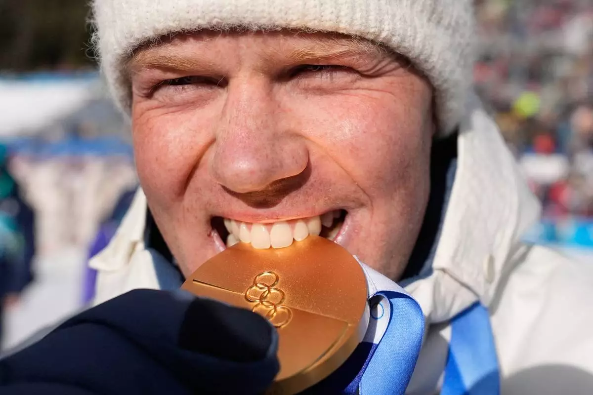 Johannes Dale-Skjevdal, of Norway, poses with the gold medal for the men's 15-kilometer mass start biathlon race at the 2026 Winter Olympics in Anterselva, Italy, Friday, Feb. 20, 2026. (AP Photo/Mosa'ab Elshamy)