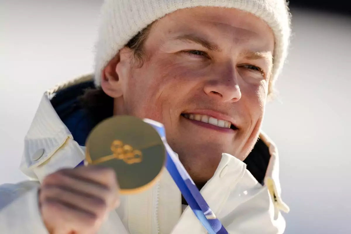 Johannes Hoesflot Klaebo, of Norway, poses after winning the gold medal in the cross country skiing men's 10km interval start free at the 2026 Winter Olympics, in Tesero, Italy, Friday, Feb. 13, 2026. (AP Photo/Evgeniy Maloletka)