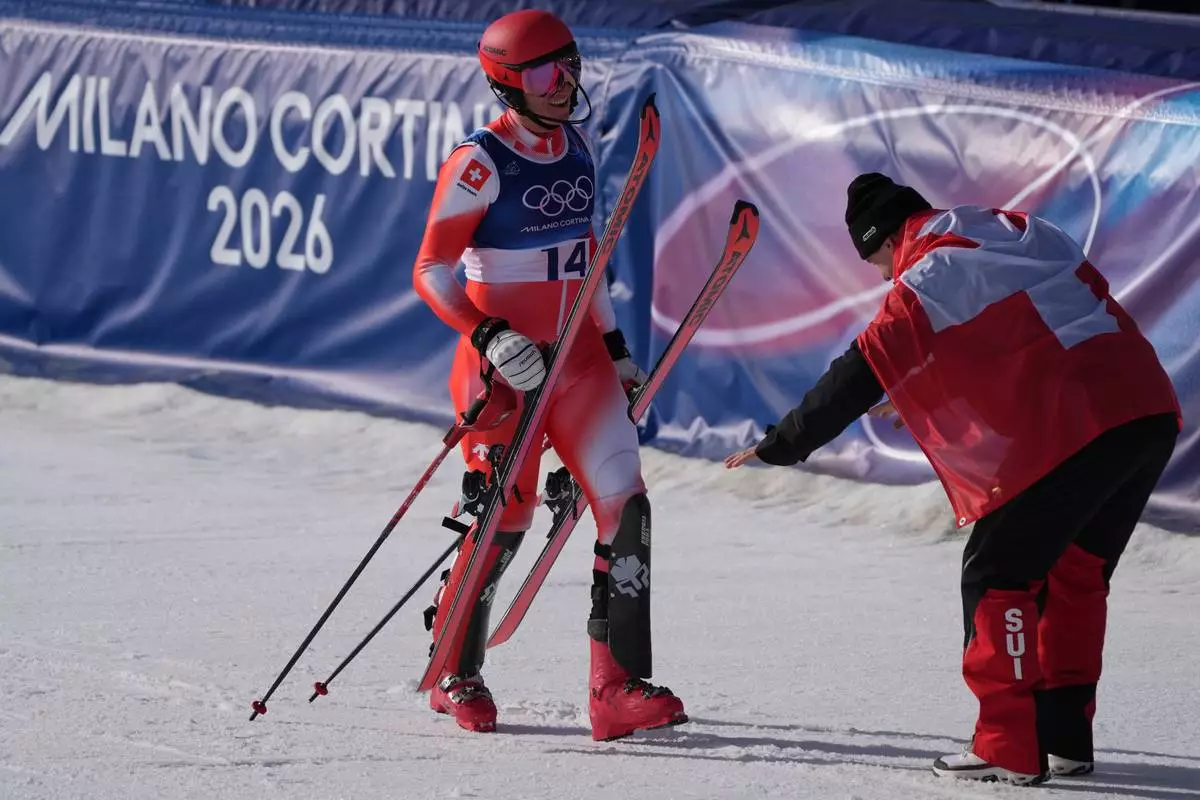 Switzerland's Franjo von Allmen, right, bows to his teammate Switzerland's Nef Tanguy at the finish area of an alpine ski men's slalom portion of a team combined race, at the 2026 Winter Olympics, in Bormio, Italy, Monday, Feb. 9, 2026. (AP Photo/Rebecca Blackwell)