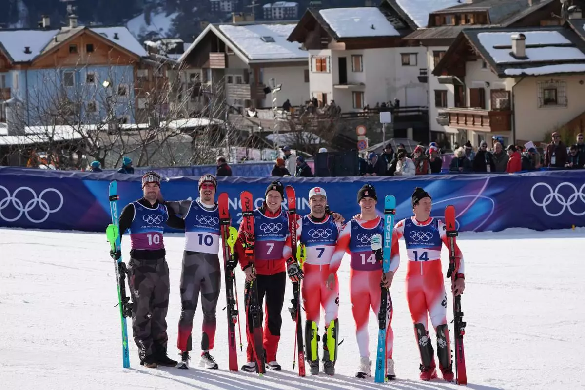 Gold medalists Switzerland's Nef Tanguy, right, and teammate Switzerland's Franjo von Allmen, second from right, stand with joint-silver medalists Switzerland's Loic Meillard, third from right, and Switzerland's Marco Odermatt, Austria's Manuel Feller, second from left, and Austria's Vincent Kriechmayr, at the finish area of an alpine ski men's slalom portion of a team combined race, at the 2026 Winter Olympics, in Bormio, Italy, Monday, Feb. 9, 2026. (AP Photo/Rebecca Blackwell)