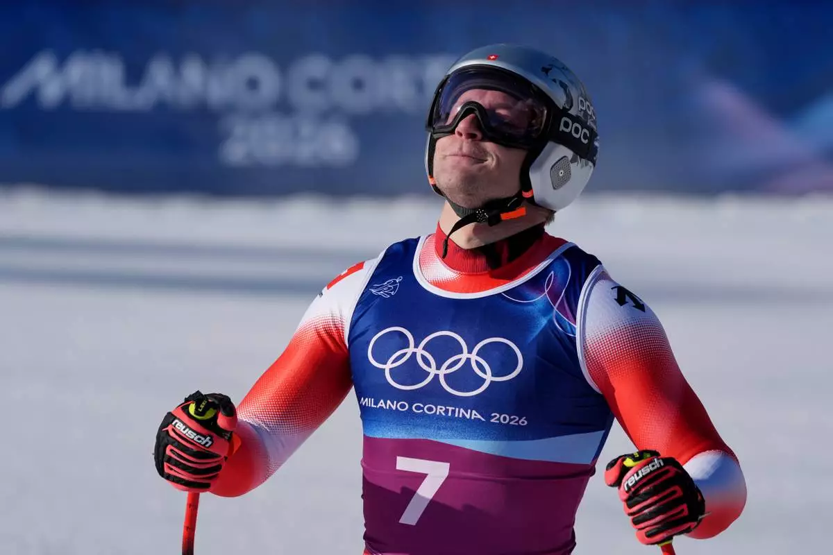 Switzerland's Marco Odermatt celebrates at the finish area of an alpine ski men's downhill portion of a team combined race, at the 2026 Winter Olympics, in Bormio, Italy, Monday, Feb. 9, 2026. (AP Photo/Rebecca Blackwell)