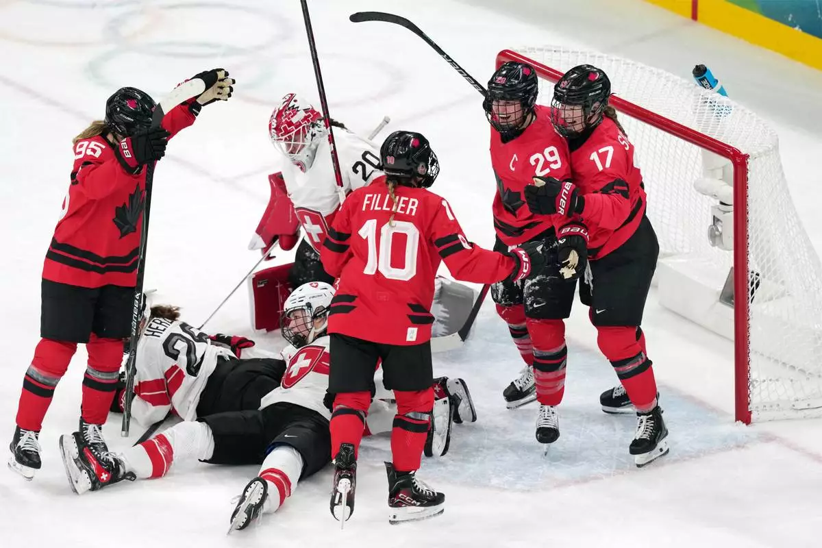 Canada's Marie-Philip Poulin (29) celebrates with Ella Shelton (17) and Sarah Fillier (10) after Poulin scored her second goal of the game against Switzerland during the second period of a women's ice hockey semifinal match at the 2026 Winter Olympics, in Milan, Italy, Monday, Feb. 16, 2026. (AP Photo/Carolyn Kaster)