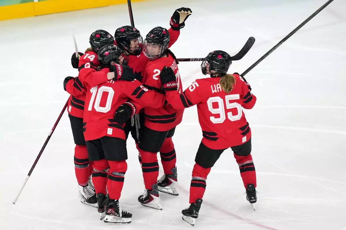 Canada's Marie-Philip Poulin, third from left, celebrates after scoring a goal against Switzerland during the second period of a women's ice hockey semifinal match at the 2026 Winter Olympics, in Milan, Italy, Monday, Feb. 16, 2026. (AP Photo/Carolyn Kaster)