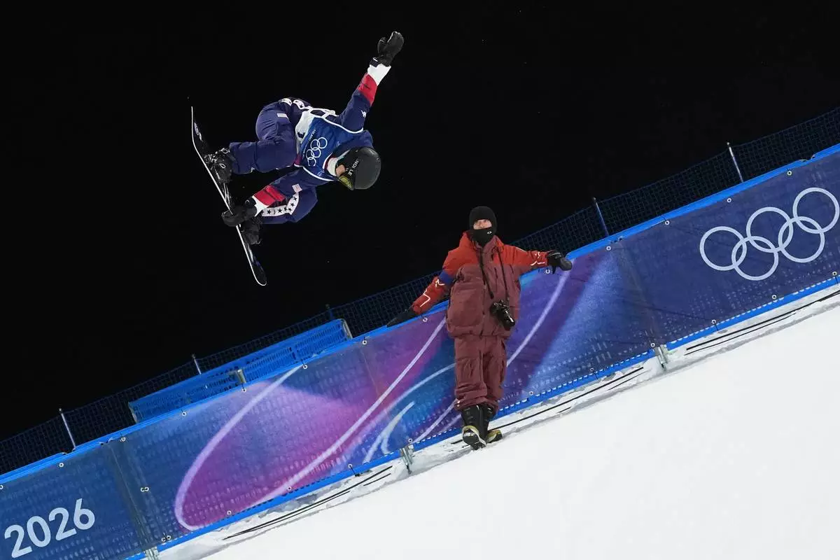 United State's Chloe Kim practices as a photographer watches during a snowboard halfpipe training session at the 2026 Winter Olympics, in Livigno, Italy, Sunday, Feb. 8, 2026. (AP Photo/Lindsey Wasson)