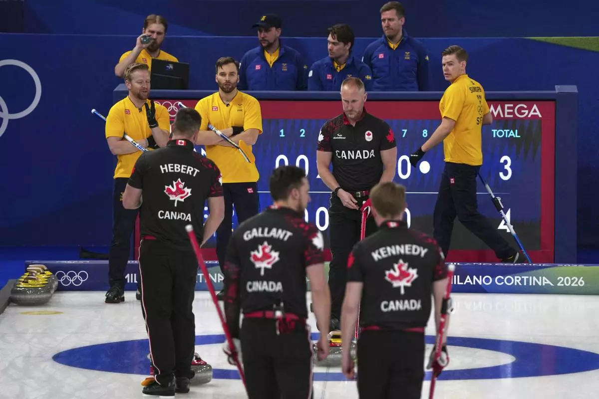 Canada's Brad Jacobs, Marc Kennedy, Brett Gallant, and Ben Hebert in action during the men's curling round robin session against Sweden, at the 2026 Winter Olympics, in Cortina d'Ampezzo, Italy, Friday, Feb. 13, 2026. (AP Photo/Misper Apawu)