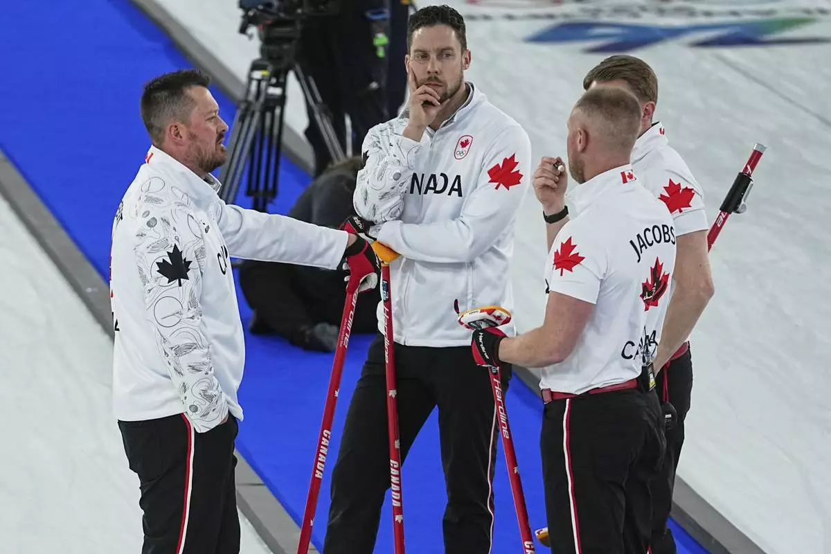 Canada's Ben Hebert, Brett Gallant, Brad Jacobs, and Marc Kennedy strategize during the men's curling round robin session against Switzerland at the 2026 Winter Olympics, in Cortina d'Ampezzo, Italy, Saturday, Feb. 14, 2026. (AP Photo/Fatima Shbair)