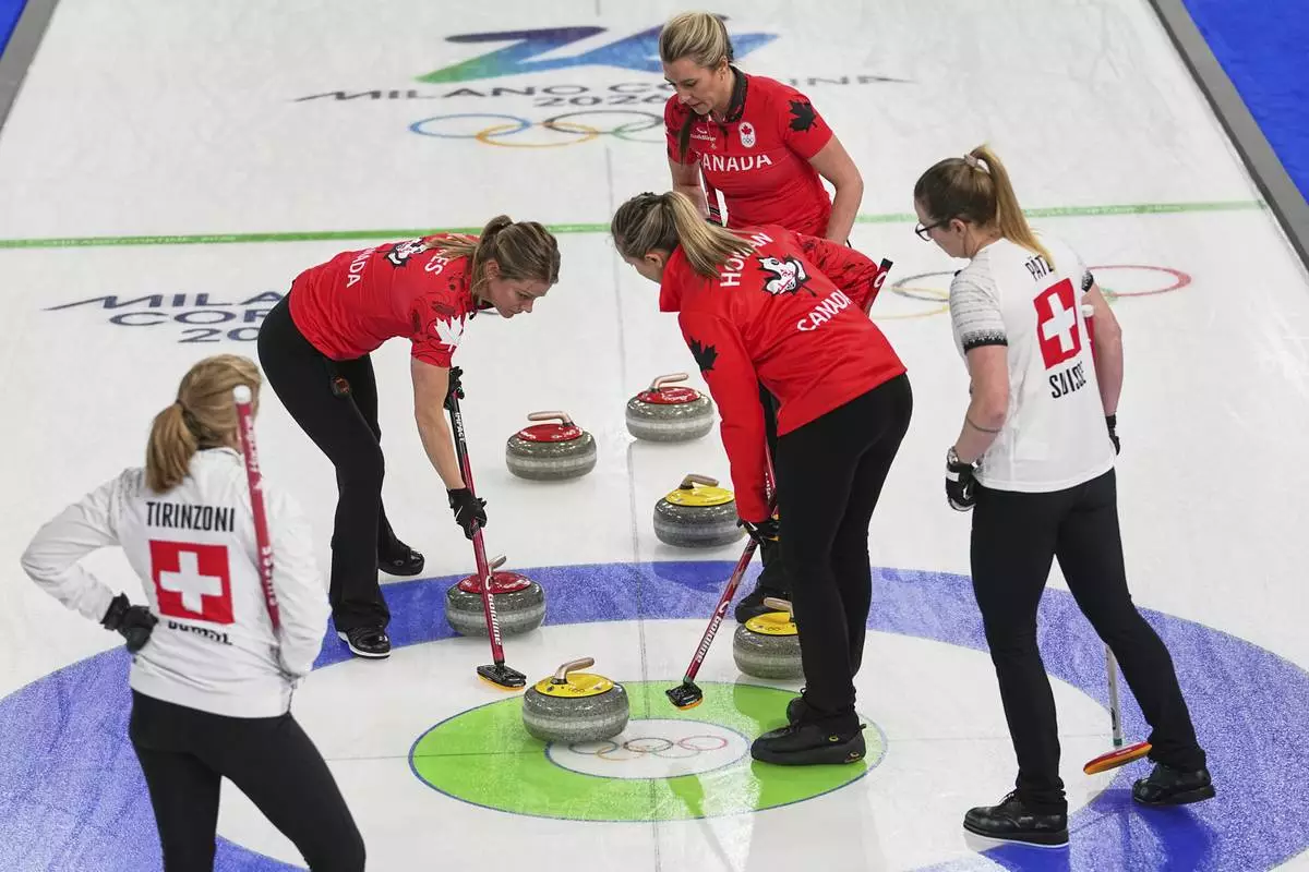 Canada's Emma Miskew, Sarah Wilkes, and Rachel Homan compete against Switzerland's Alina Paetz and Silvana Tirinzoni during the women's curling round robin session at the 2026 Winter Olympics, in Cortina d'Ampezzo, Italy, Saturday, Feb. 14, 2026. (AP Photo/Fatima Shbair)