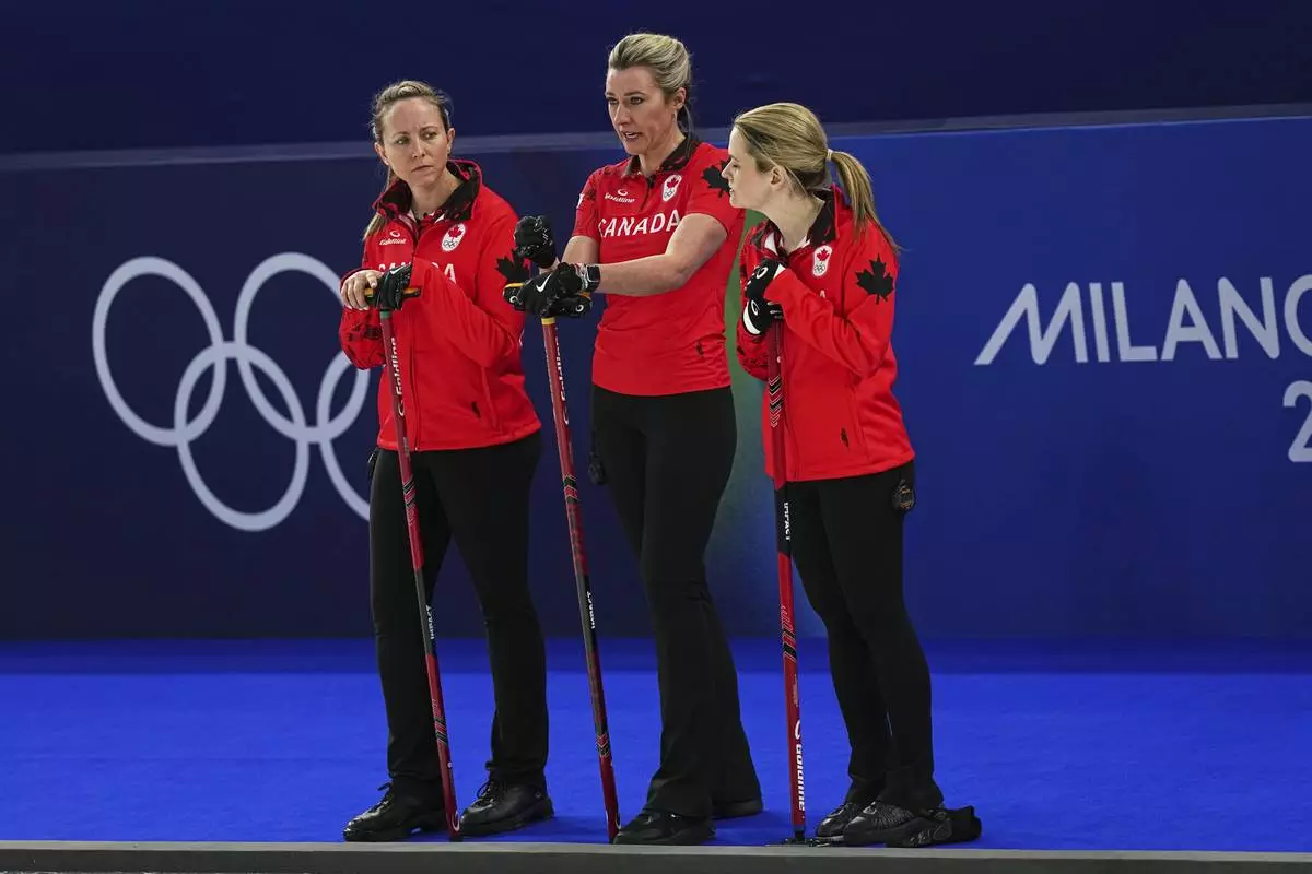 Canada's Rachel Homan, Emma Miskew and Tracy Fleury strategize during the women's curling round robin session against Switzerland at the 2026 Winter Olympics, in Cortina d'Ampezzo, Italy, Saturday, Feb. 14, 2026. (AP Photo/Fatima Shbair)