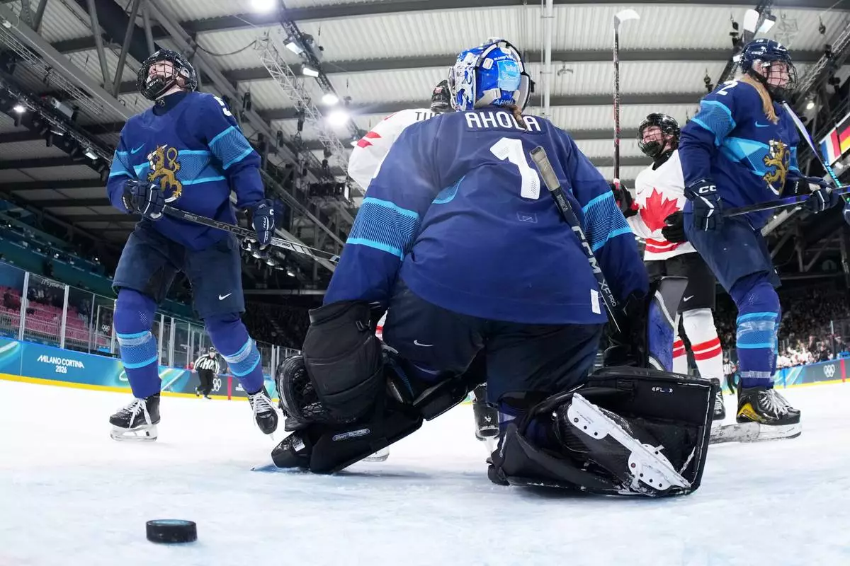 Canada's Emily Clark, second right, celebrates after scoring her side's sixth goal during a preliminary round match of women's ice hockey between Finland and Canada at the 2026 Winter Olympics, in Milan, Italy, Thursday, Feb. 12, 2026. (Sun Fei/Pool Photo via AP)