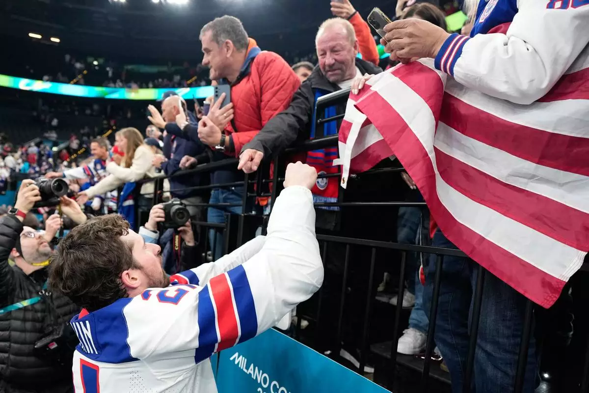 United States' Dylan Larkin (21) celebrates with fans after the men's ice hockey gold medal game between Canada and the United States at the 2026 Winter Olympics, in Milan, Italy, Sunday, Feb. 22, 2026. (AP Photo/Hassan Ammar)