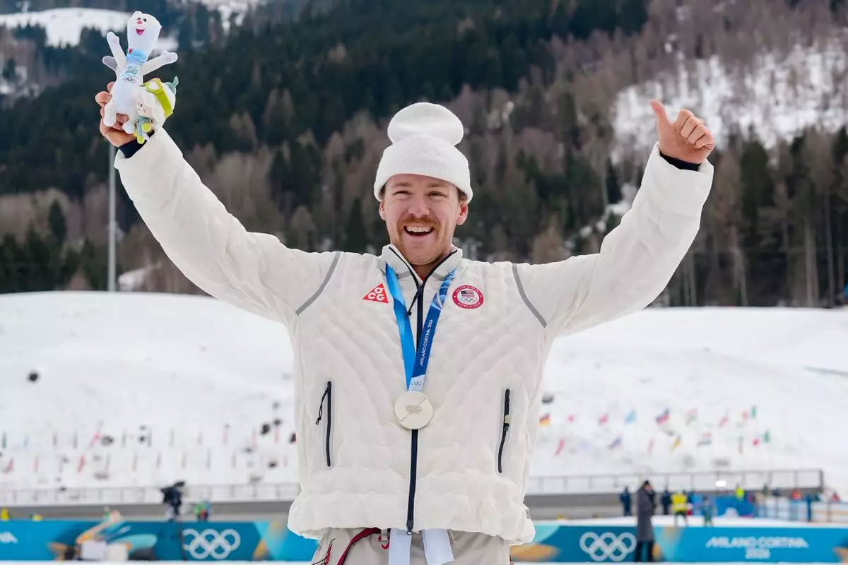 Ben Ogden, of the United States, poses after winning the silver medal in the cross-country skiing men's sprint classic at the 2026 Winter Olympics, in Tesero, Italy, Tuesday, Feb. 10, 2026. (AP Photo/Evgeniy Maloletka)