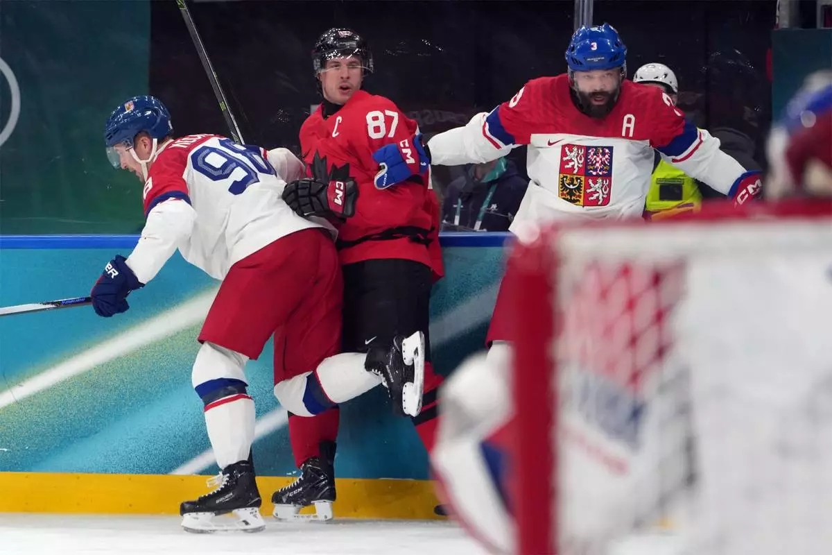Canada's Sidney Crosby (87) is hit against the boards by Czechia's Martin Necas (98) and Radko Gudas (3) during the second period of a men's ice hockey quarterfinal game at the 2026 Winter Olympics, in Milan, Italy, Wednesday, Feb. 18, 2026. Crosby went to the dressing room after the play. (AP Photo/Carolyn Kaster)