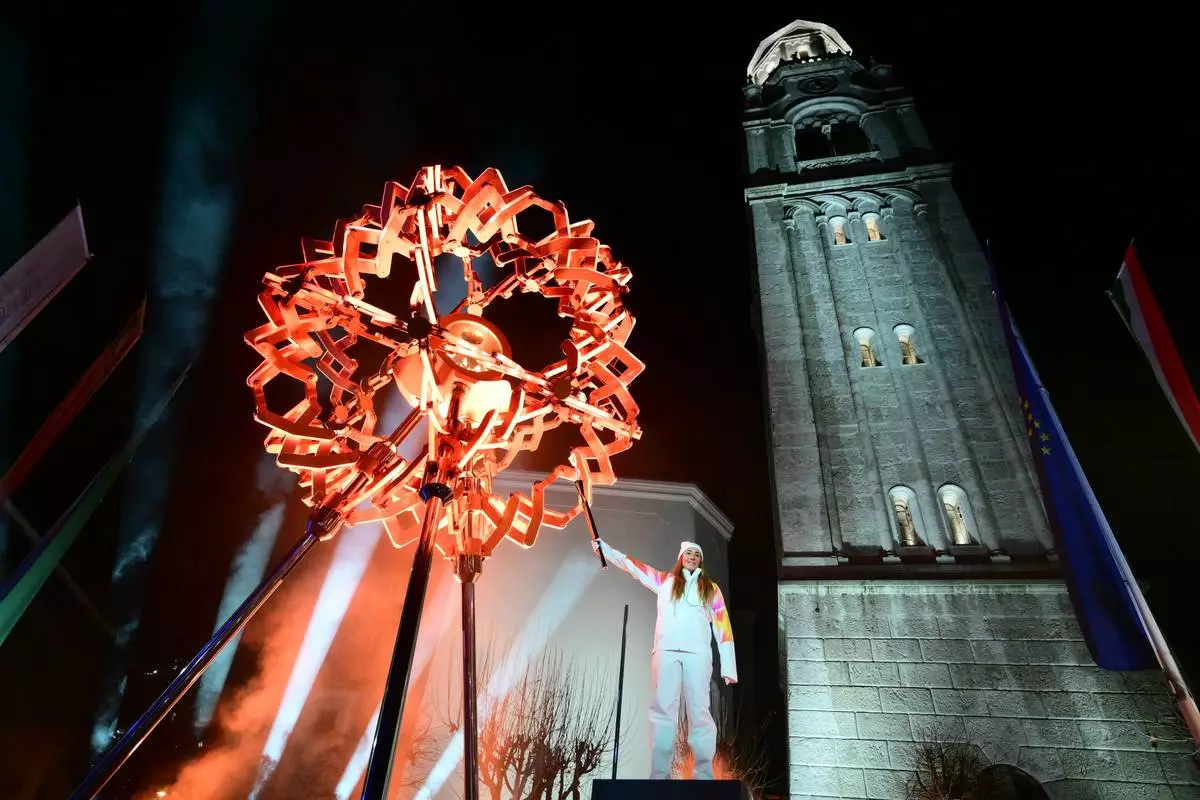 Final torchbearer Italian skier Sofia Goggia uses the torch of the Olympic flame to light the Olympic cauldron designed by Marco Balich during the Olympic opening ceremony at the 2026 Winter Olympics, in in Cortina d'Ampezzo, Italy, Friday, Feb. 6, 2026. (Stefano Rellandini/Pool Photo via AP)