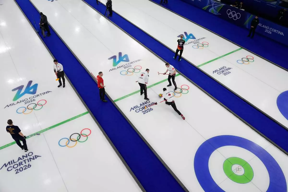 Canada's Ben Hebert, Brett Gallant and Marc Kennedy compete during a men's curling round robin match against Switzerland at the 2026 Winter Olympics, in Cortina d'Ampezzo, Italy, Saturday, Feb. 14, 2026. (AP Photo/David J. Phillip)