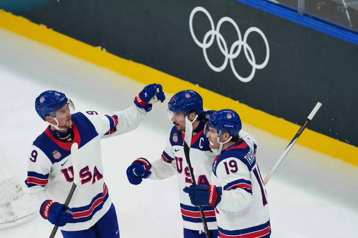 United States' Auston Matthews, center, celebrates with teammates after scoring his sides fifth goal during a preliminary round match of men's ice hockey between Latvia and the United States at the 2026 Winter Olympics, in Milan, Italy, Thursday, Feb. 12, 2026. (AP Photo/Carolyn Kaster)