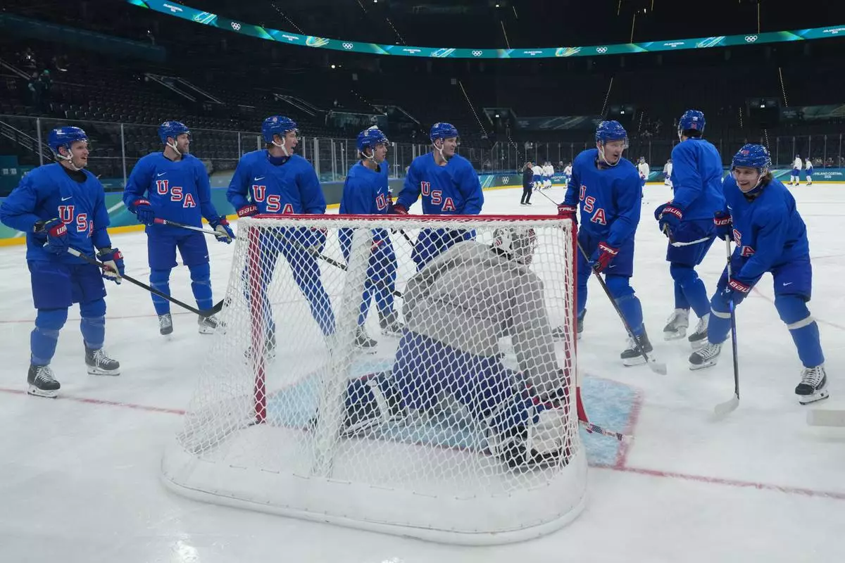 Members of the United States men's ice hockey team including Brady Tkachuk, third from right, Auston Matthews, second from right, and United States' Jack Hughes, right, gather around the net during men's ice hockey practice at the 2026 Winter Olympics, in Milan, Italy, Sunday, Feb. 8, 2026. (AP Photo/Carolyn Kaster)