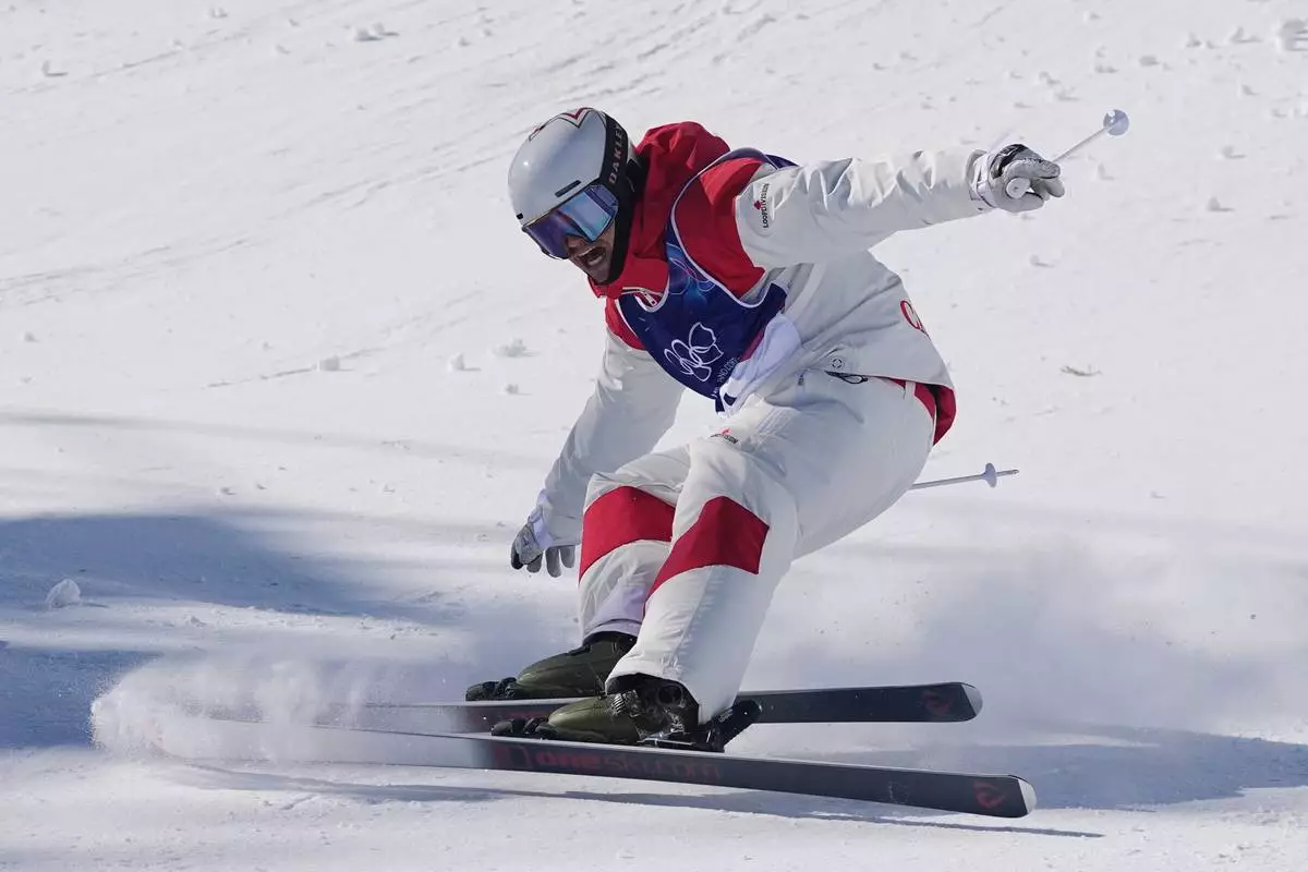 Canada's Mikael Kingsbury (4) celebrates after winning the gold medal during the men's freestyle skiing dual moguls finals at the 2026 Winter Olympics, in Livigno, Italy, Sunday, Feb. 15, 2026. (AP Photo/Gregory Bull)