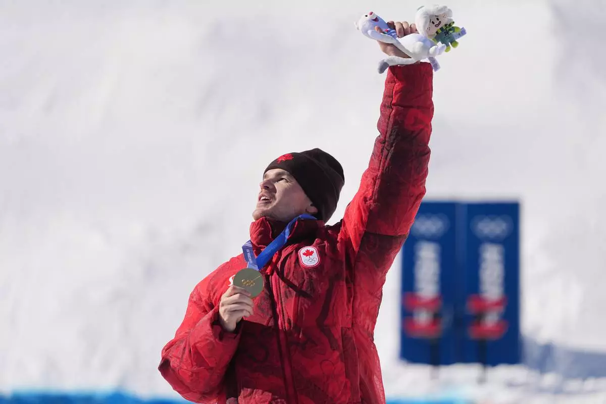 Gold medalist Canada's Mikael Kingsbury (4) celebrates after the men's freestyle skiing dual moguls finals at the 2026 Winter Olympics, in Livigno, Italy, Sunday, Feb. 15, 2026. (AP Photo/Gregory Bull)