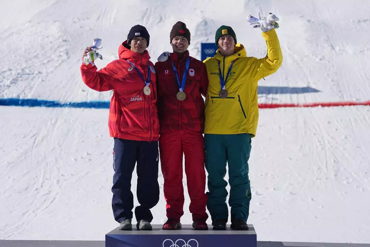 From left, silver medalist Japan's Ikuma Horishima (2), gold medalist Canada's Mikael Kingsbury (4), and bronze medalist Australia's Matt Graham (6) celebrate after the men's freestyle skiing dual moguls finals at the 2026 Winter Olympics, in Livigno, Italy, Sunday, Feb. 15, 2026. (AP Photo/Gregory Bull)