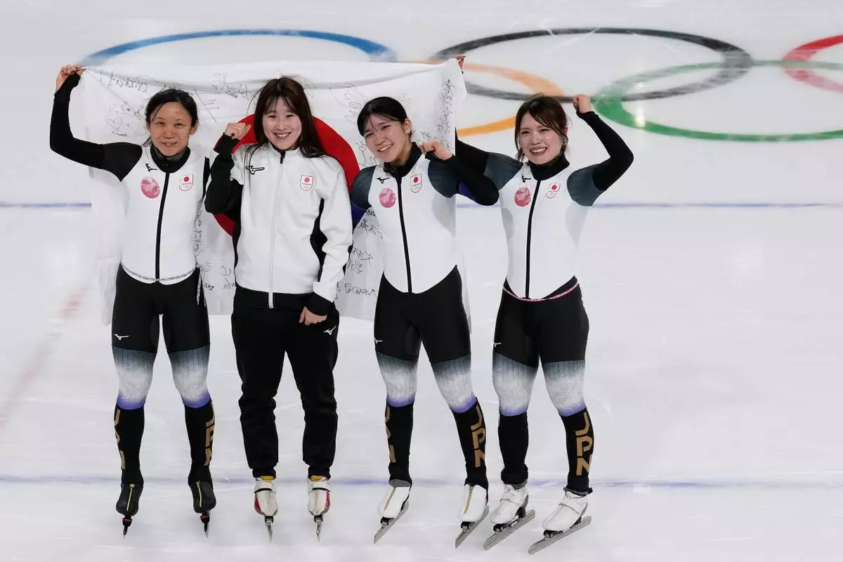 Team Japan with Momoka Horikawa, Ayano Sato, Miho Takagi, and Hana Noake, celebrate winning the bronze medal in the women's team pursuit speedskating race at the 2026 Winter Olympics, in Milan, Italy, Tuesday, Feb. 17, 2026. (AP Photo/Luca Bruno)