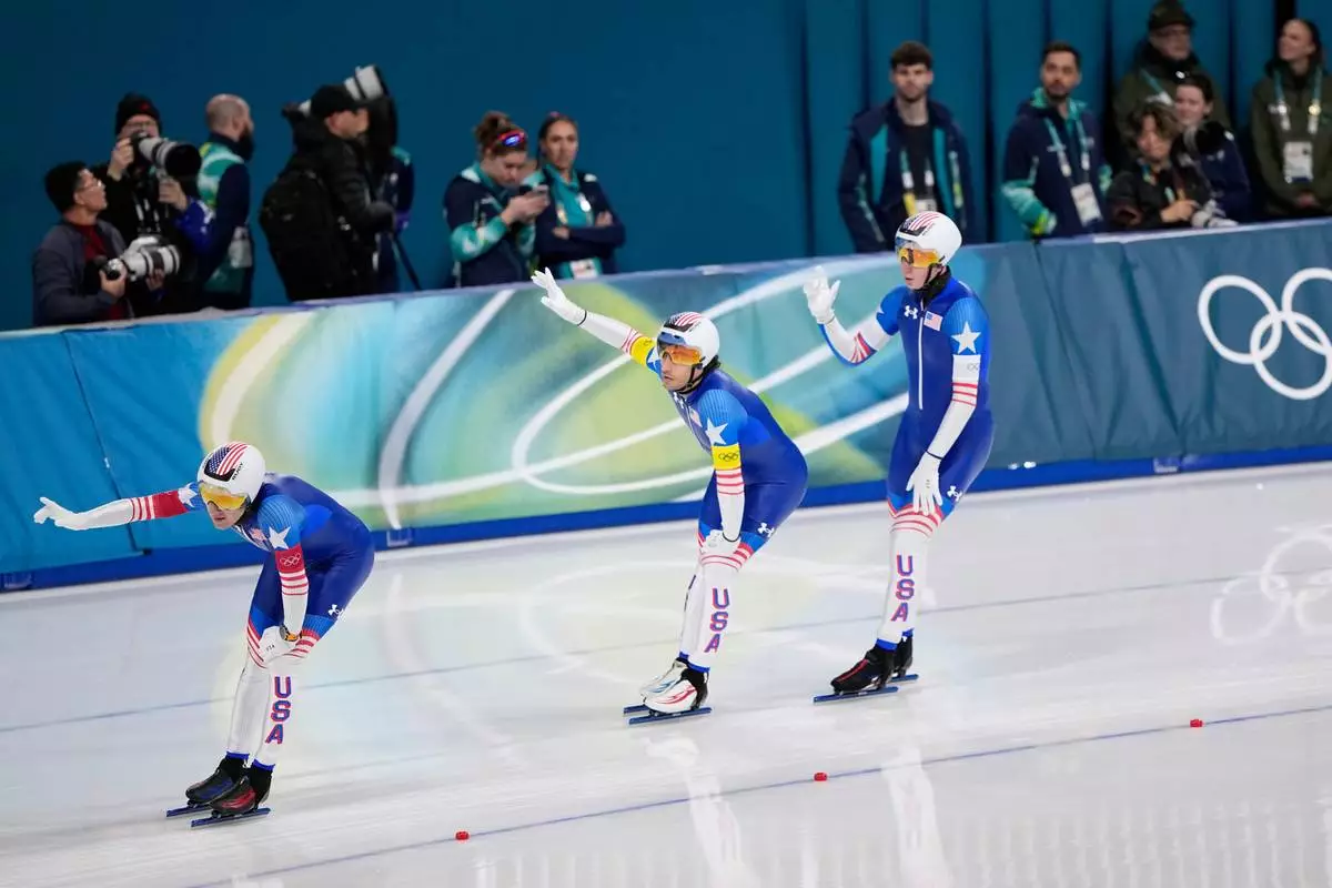 Team USA with Ethan Cepuran, white armband, Casey Dawson, red armband, and Emery Lehman, yellow armband, celebrates after winning the semifinal of the men's team pursuit speedskating race at the 2026 Winter Olympics, in Milan, Italy, Tuesday, Feb. 17, 2026. (AP Photo/Ben Curtis)