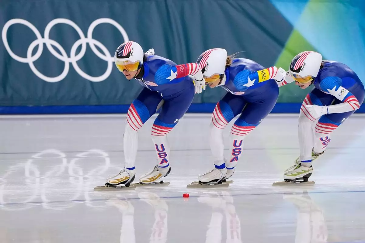 Team USA with Giorgia Birkeland, white armband, Brittany Bowe, red armband, Mia Manganello, yellow armband, competes in the semifinal of the women's team pursuit speedskating race at the 2026 Winter Olympics, in Milan, Italy, Tuesday, Feb. 17, 2026. (AP Photo/Ben Curtis)