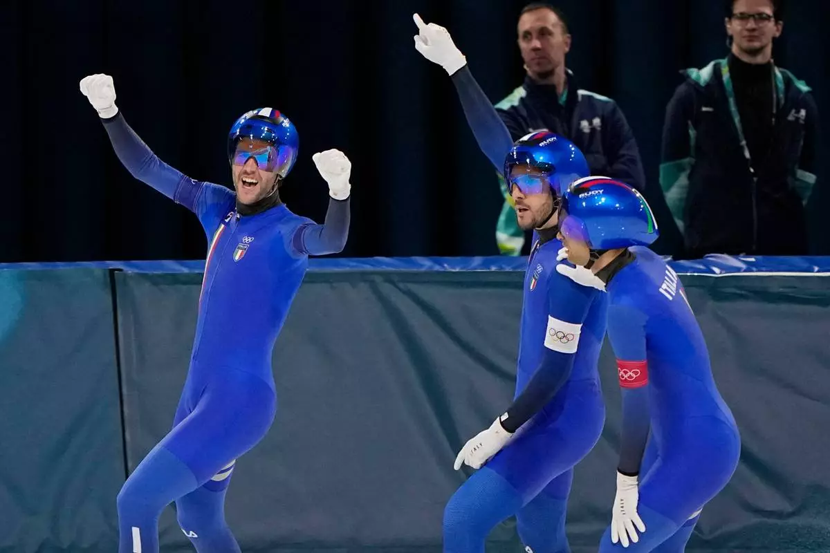 Team Italy with Davide Ghiotto, white armband, Andrea Giovannini, red armband, and Michele Malfatti, blue armband, celebrate after winning the semifinal of the men's team pursuit speedskating race at the 2026 Winter Olympics, in Milan, Italy, Tuesday, Feb. 17, 2026. (AP Photo/Ben Curtis)