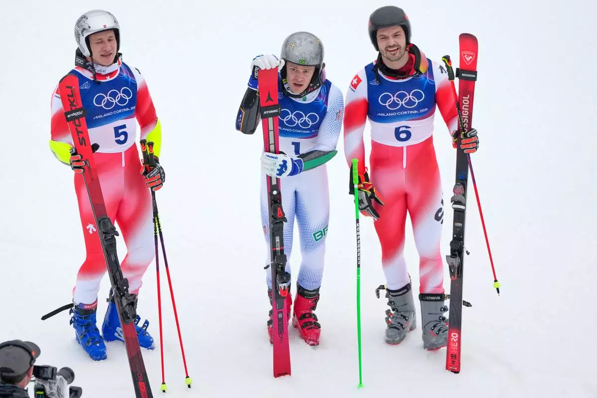 Brazil's Lucas Pinheiro Braathen,center, winner of an alpine ski, men's giant slalom race, poses with second placed Switzerland's Marco Odermatt, left, and third placed Switzerland's Loic Meillard, at the 2026 Winter Olympics, in Bormio, Italy, Saturday, Feb. 14, 2026. (AP Photo/John Locher)