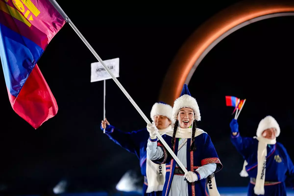 Ariuntungalag Enkhbayar, the flag bearer of Mongolia, takes part in the athletes parade during the Olympic opening ceremony at the 2026 Winter Olympics, in Predazzo, Italy, Friday, Feb. 6, 2026. (AP Photo/Matthias Schrader)