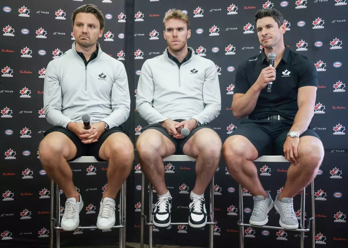 FILE - Team Canada hockey players, left to right, Sam Reinhart, Connor McDavid and Sidney Crosby speak to the media at Hockey Canada's National Teams orientation camp in Calgary, Alberta, Wednesday, Aug. 27, 2025. (Jeff McIntosh/The Canadian Press via AP, File)