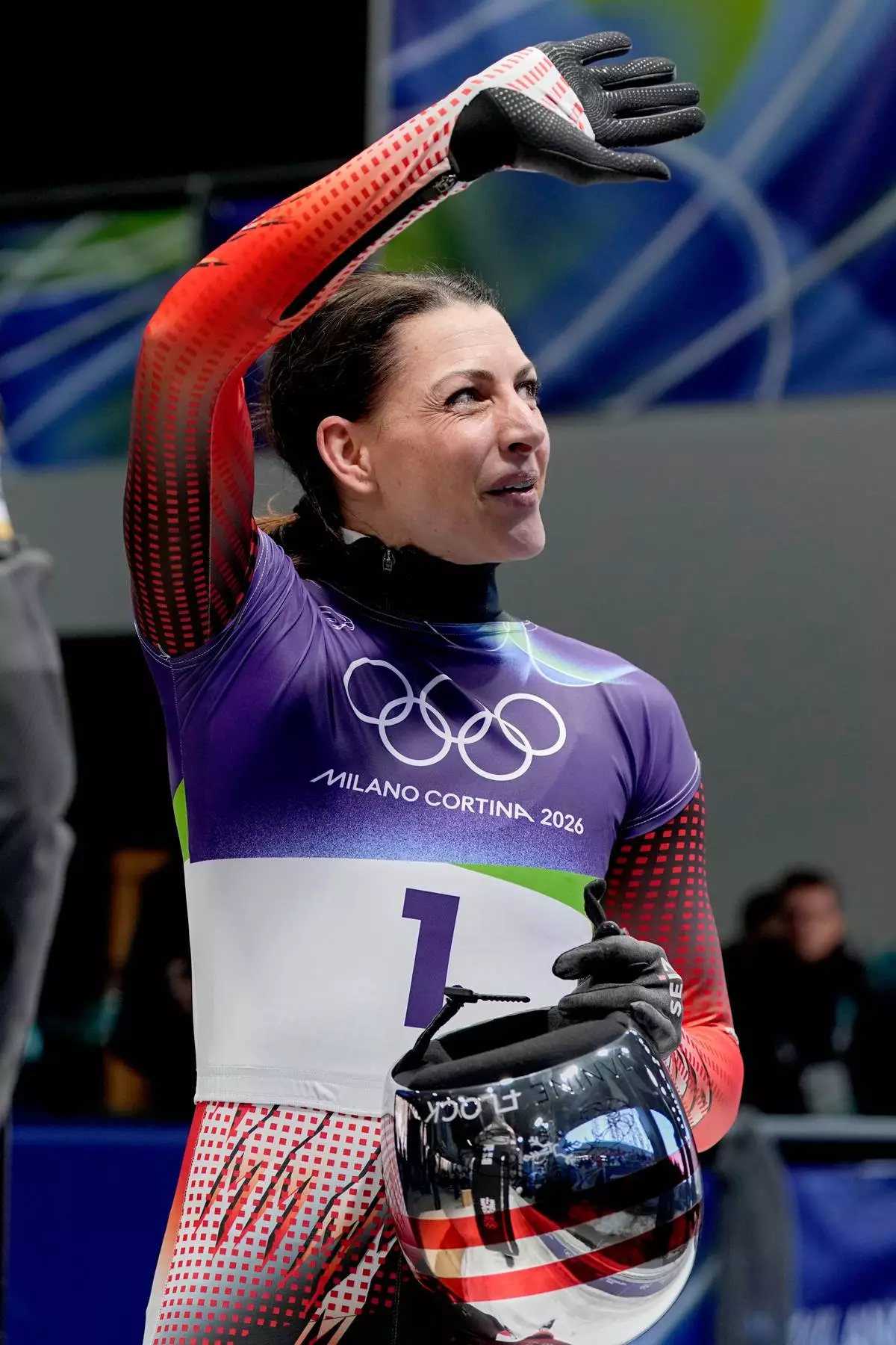 Austria's Janine Flock waves as she arrives at the finish during a women's skeleton run at the 2026 Winter Olympics, in Cortina d'Ampezzo, Italy, Friday, Feb. 13, 2026. (AP Photo/Alessandra Tarantino)